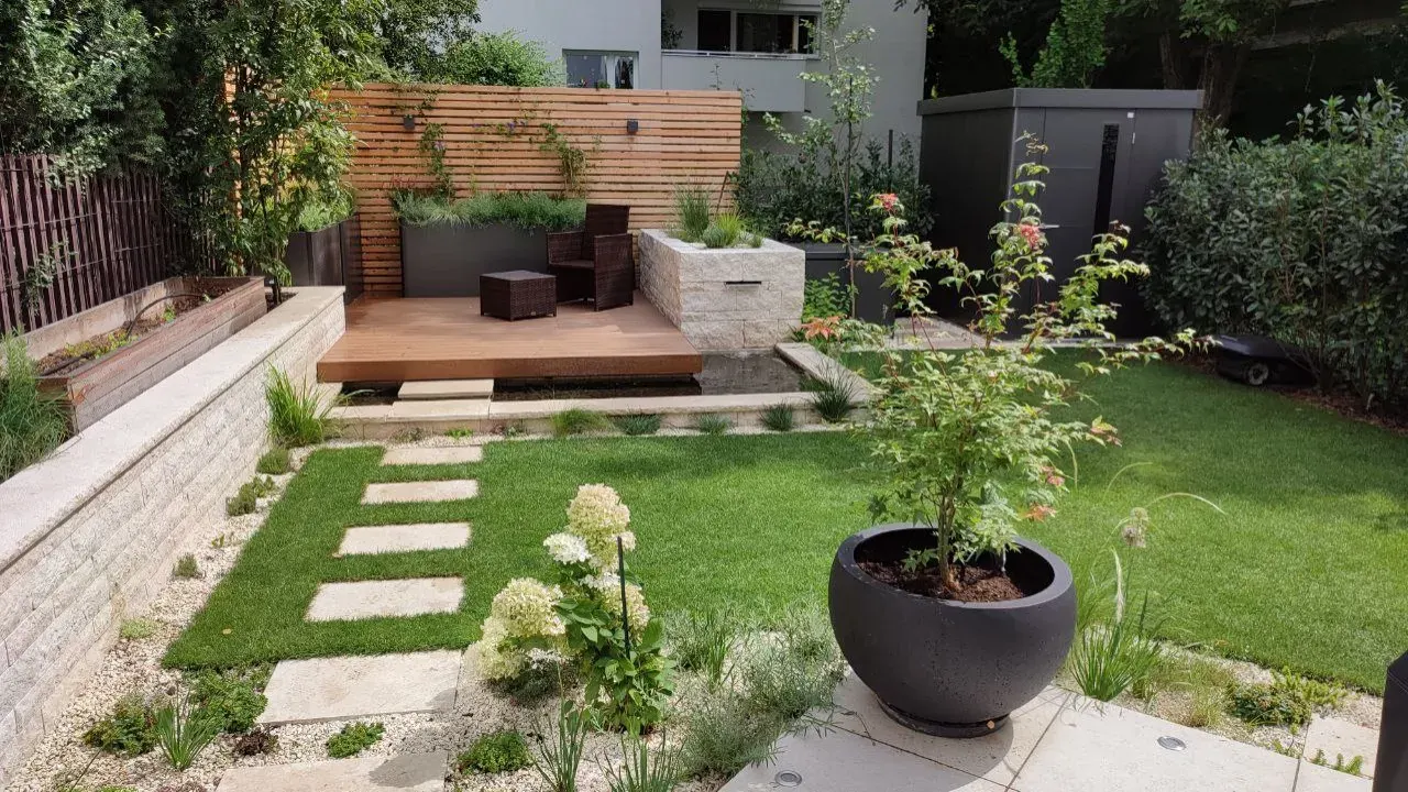 Der umgesetzte Garten: Holzdeck über dem Wasserbecken, Sichtschutz aus Holz, Hochbeet aus Naturstein, Trittplatten im Rasen und anthrazitfarbener Geräteschuppen